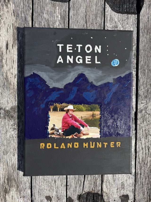 The first Teton Angel cover, hand-painted by Roland Hunter: stars and a blue moon over dark blue Tetons, with his photo set into the mountains